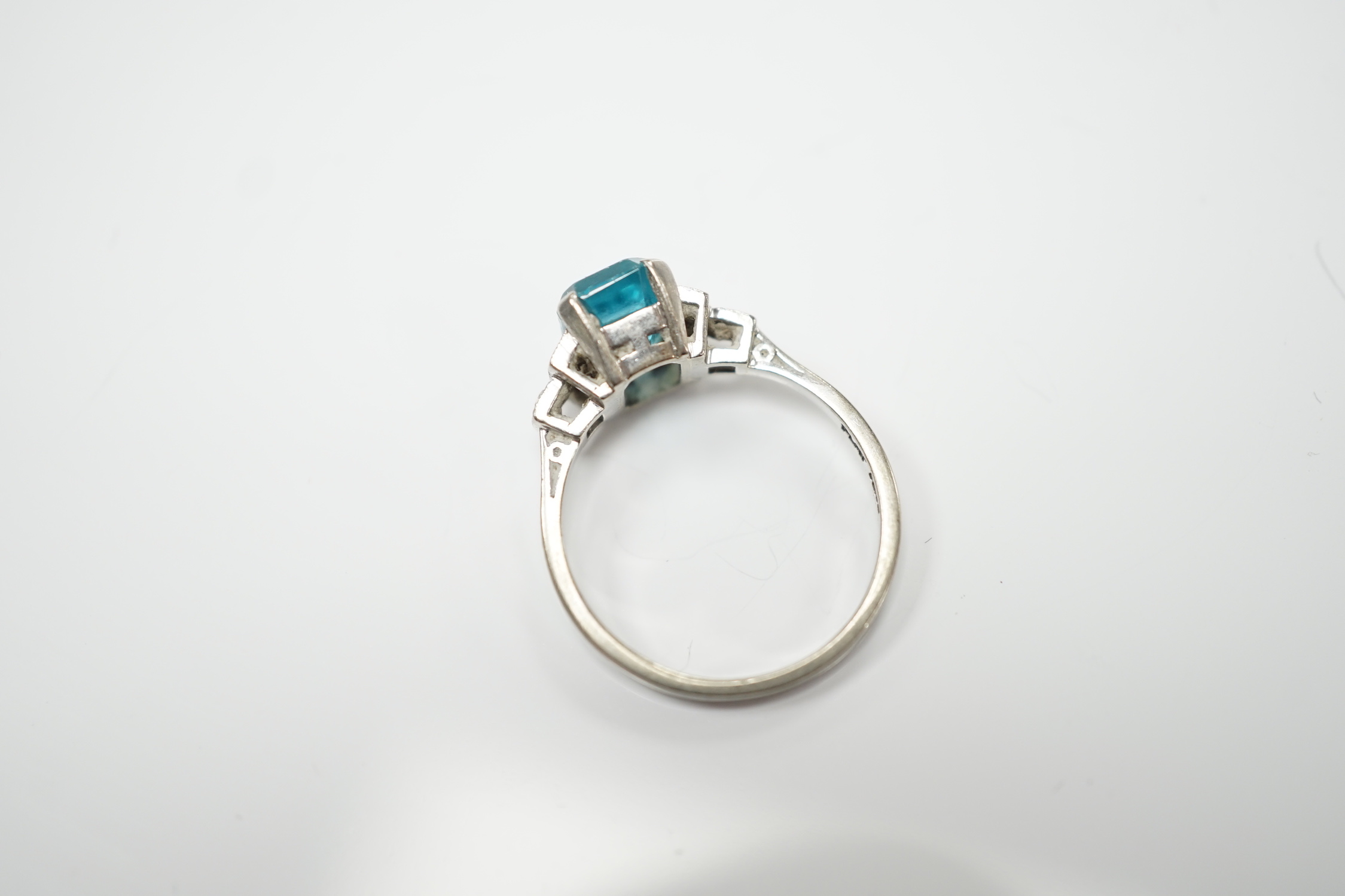 An 18ct, plat and single stone emerald cut blue zircon set ring, with six stone diamond set shoulders, size L, gross weight 2.9 grams.